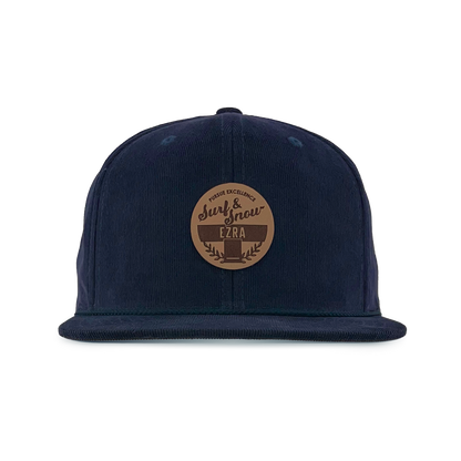Navy blue corduroy cap with a brown leather patch on a white background