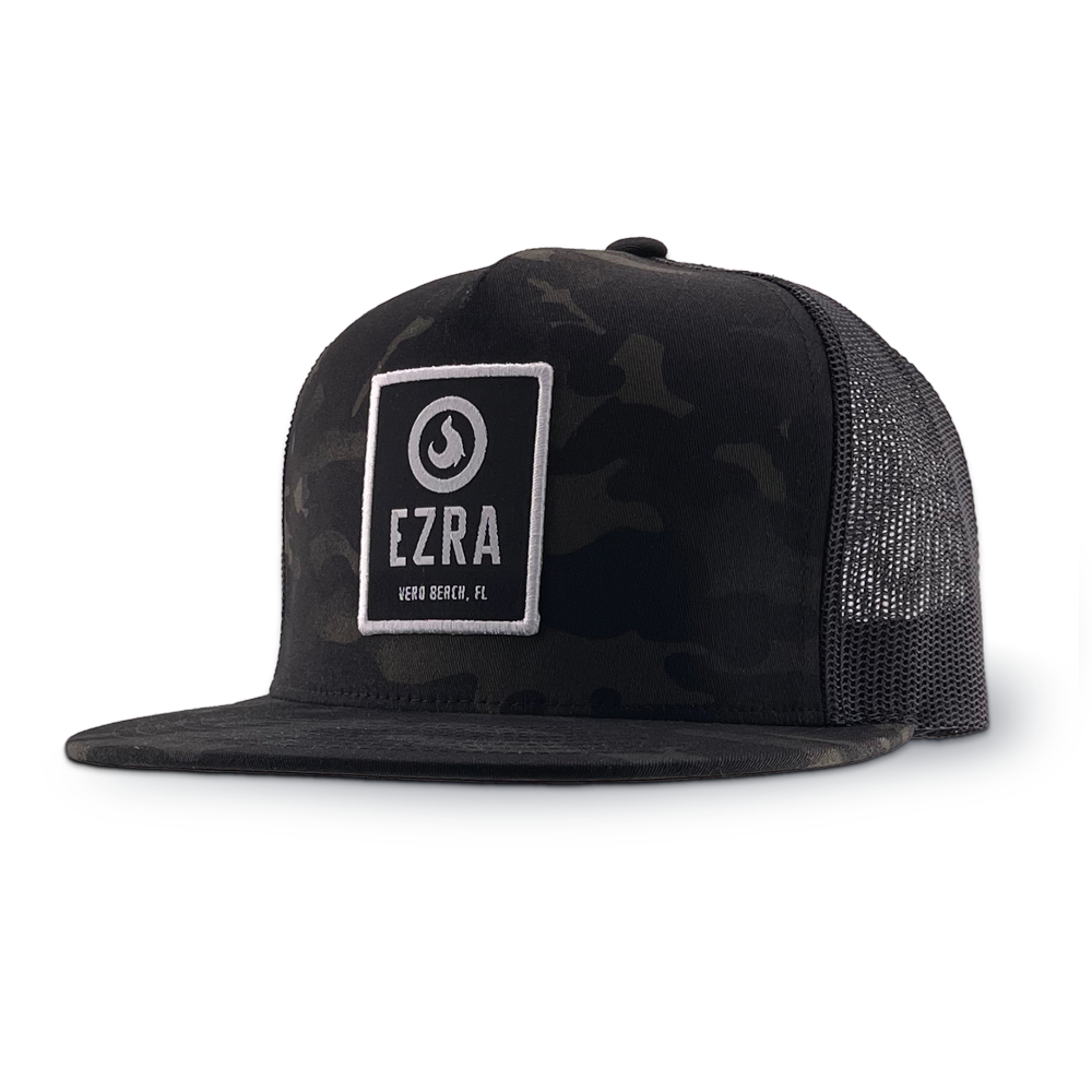 Black camouflage trucker hat with 'EZRA' logo patch on a white background