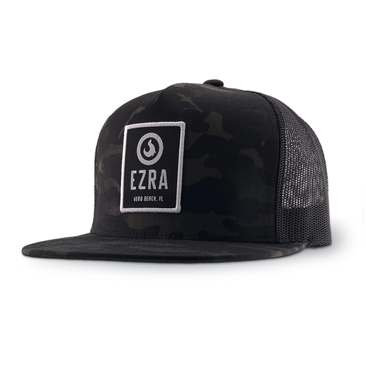 Black camouflage trucker hat with 'EZRA' logo patch on a white background