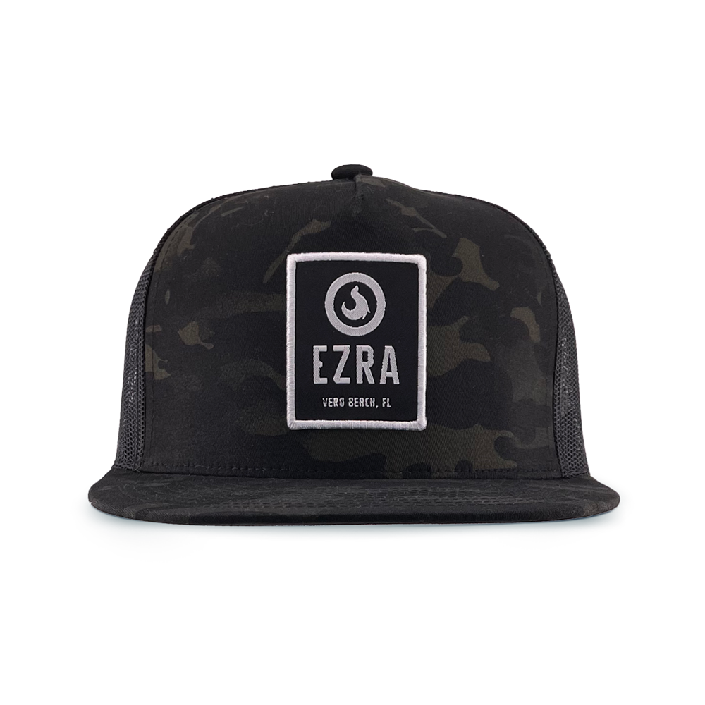 Black camouflage trucker hat with 'EZRA' logo patch on a white background