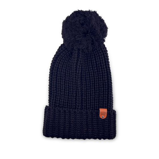 Black color knitted beanie toque with a pom-pom on a white background