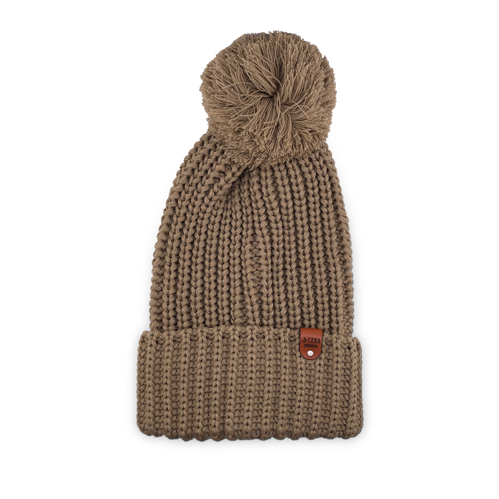 Tan color knitted beanie toque with a pom-pom on a white background